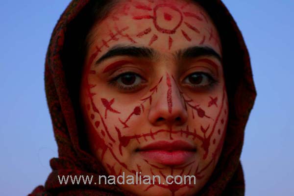 طراحی های احمد نادعلیان بر روی چهره ها با استفاده از خاک سرخ جزیره هرمز، جشنواره هنر محیطی در جزیره هرمز، بهمن 1385
