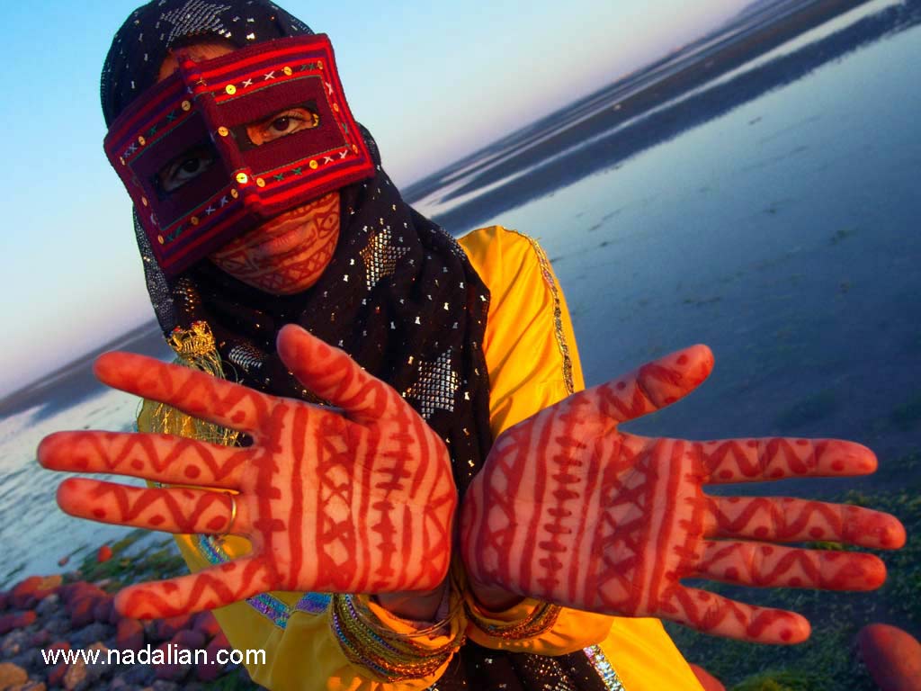 نقاشی با خاک سرخ جزیره هرمز، بر روی دستها و چهره ای یکی از دختران شرکت کننده، در ساحل "مغ ناخا" بندر عباس