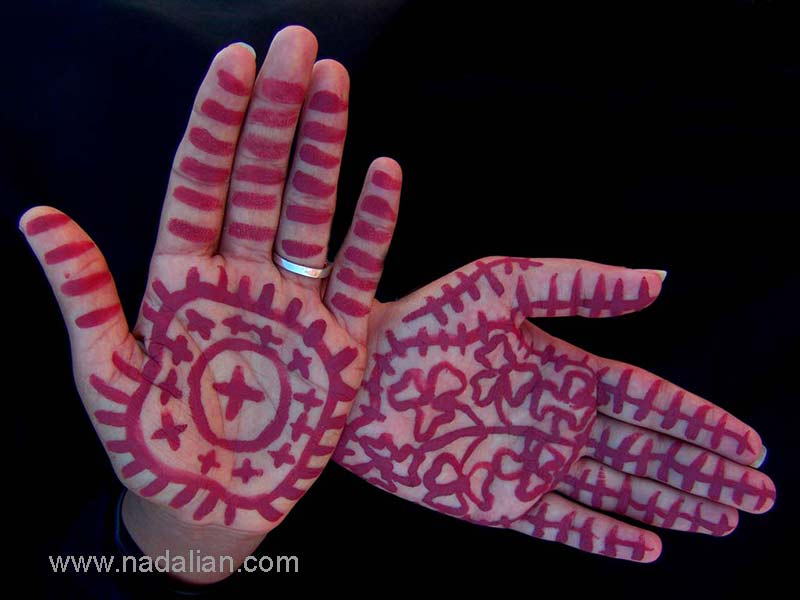نقاشی با خاک سرخ جزیره هرمز، بر روی دستهای یکی از دختران شرکت کننده، در ساحل "مغ ناخا" بندر عباس