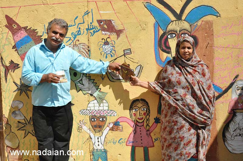 احمد نادعلیان و کنیز در مقابل نقاشی کنیز با کمک دخترش صغری در داخل حیاط خانه اش در جزیره هرمز، او باید به نادعلیان نقاشی بدهد تا پول بگیرد.