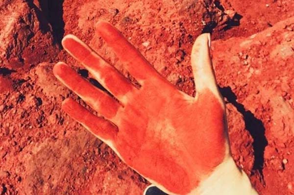 دست گردشگر رنگ آمیزی شده با خاک سرخ در جزیره هرمز