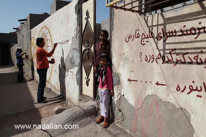 هنرمندان در حال دیوار نویسی و نقاشی دیواری کوچه های مقابل منبر مقابل حسینیه در جزیره هرمز. اینجا نزدیک ترین جایی بود که وسیله نقلیه توقف می کرد. 
