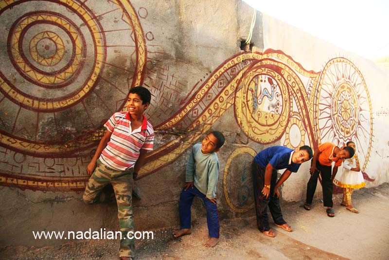 کودکان هرمزی در کنار نقاشی های دیواری مسیر هنرمند سرا و موزه فعلی دکتر نادعلیان در جزیره هرمز