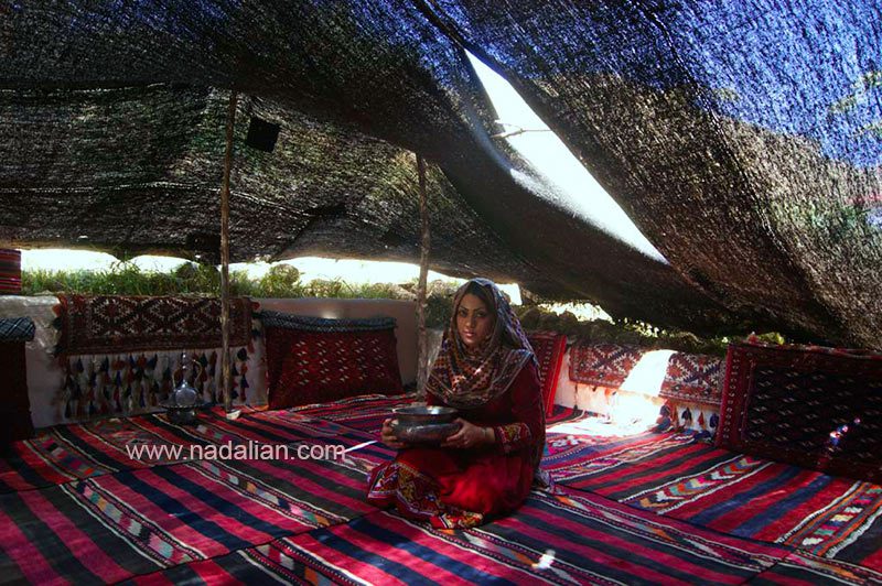 زن سنگسری با ظرف آب چشمه در داخل گوت (چادر خیلی بزرگ سیاه رنگ بافته شده از موی بز)